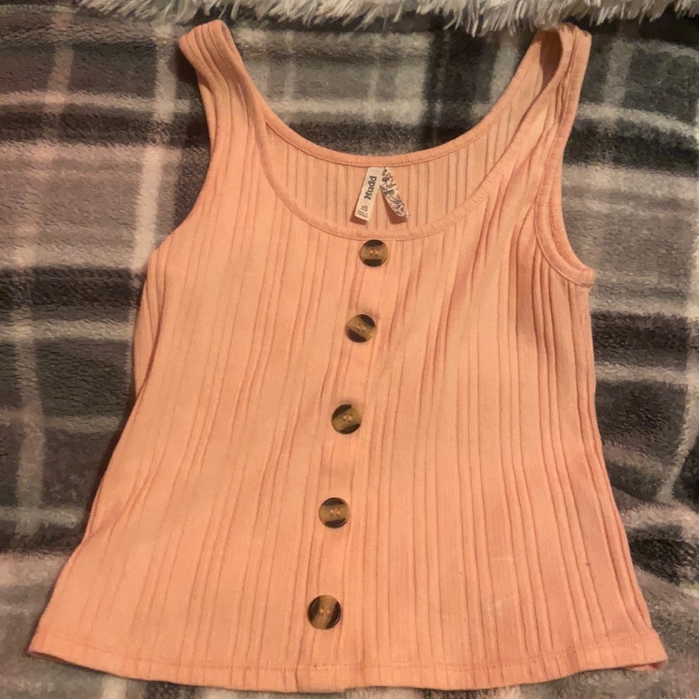 a pink tank top; buttons are just for show they don’t actually unbutton